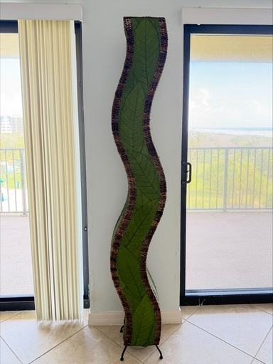 Green Wave Giant floor lamp on a tiled floor between balcony doors in a customer home.
